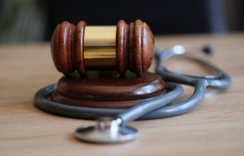 judge gavel and doctor stethoscope on lawyer office desk