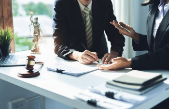 attorney or lawyer holding a pen is consulting with a client